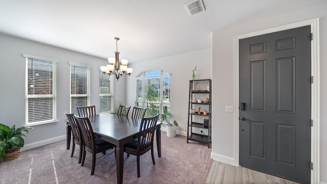 dining area featuring a chandelier and baseboards