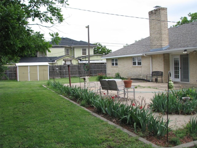 view of yard featuring a patio area, a shed, and an outbuilding