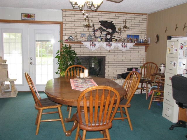 dining area with a fireplace, french doors, carpet flooring, ornamental molding, and a textured ceiling