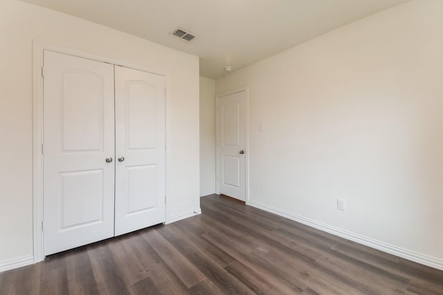 510 E Shepherd St, Denison, TX 75021 - unfurnished bedroom featuring dark wood-style floors, baseboards, and a closet