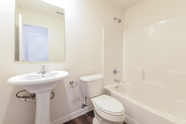 510 E Shepherd St, Denison, TX 75021 - full bath with baseboards, toilet, bathing tub / shower combination, and wood finished floors