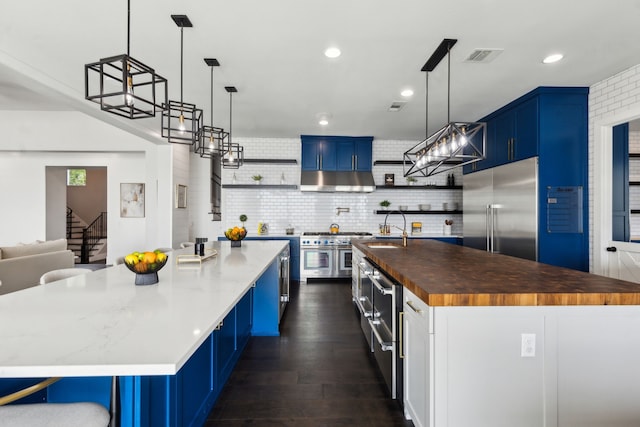 1210 Emerald Sound Blvd, Oak Point, TX 75068 - kitchen with premium appliances, butcher block countertops, open shelves, blue cabinets, and a spacious island