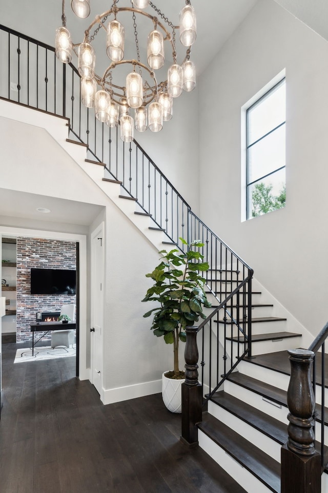 1210 Emerald Sound Blvd, Oak Point, TX 75068 - stairway with wood-type flooring, baseboards, a towering ceiling, and a chandelier