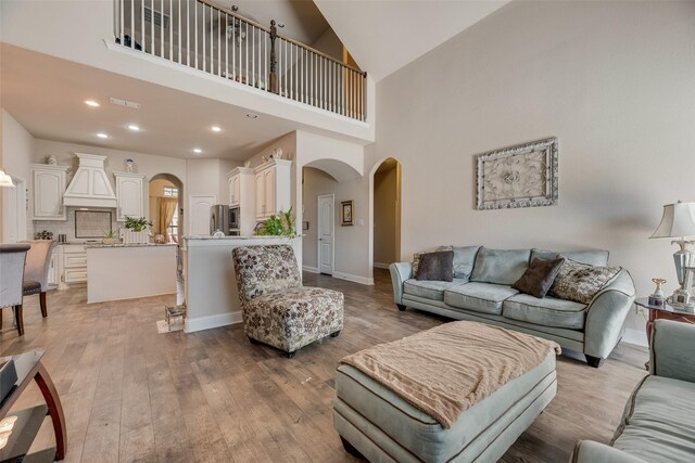 1537 Firenza Ct, Mclendon Chisholm, TX 75032 - living area featuring arched walkways, light wood-style flooring, high vaulted ceiling, recessed lighting, and baseboards