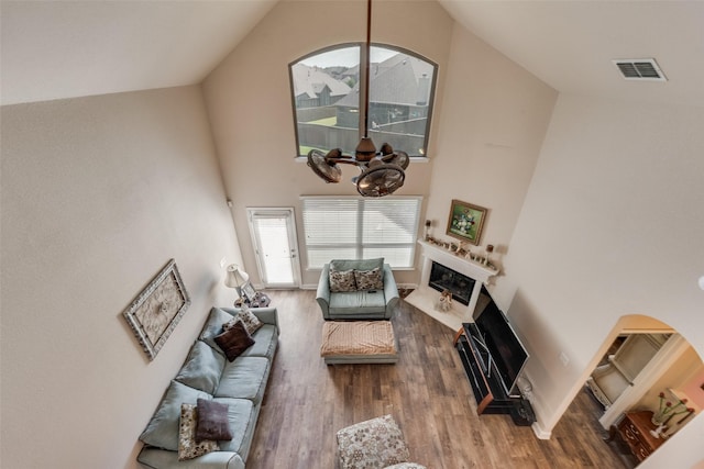 1537 Firenza Ct, Mclendon Chisholm, TX 75032 - living room featuring a fireplace with flush hearth, wood finished floors, high vaulted ceiling, and a chandelier