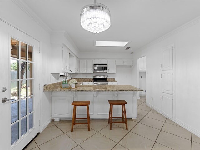 3804 Chestnut St, Fort Worth, TX 76137 - kitchen featuring appliances with stainless steel finishes, a peninsula, white cabinetry, ornamental molding, and light tile patterned floors