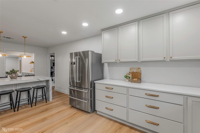 4131 Waller Dr, Shreveport, LA 71119 - kitchen featuring high quality fridge, light wood-style flooring, pendant lighting, recessed lighting, and a breakfast bar area