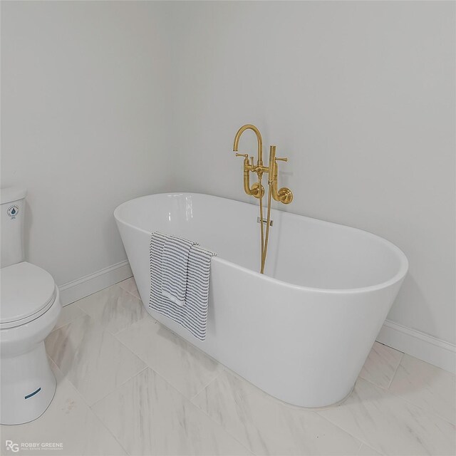 4131 Waller Dr, Shreveport, LA 71119 - full bath with marble look tiles, baseboards, a freestanding bath, and toilet