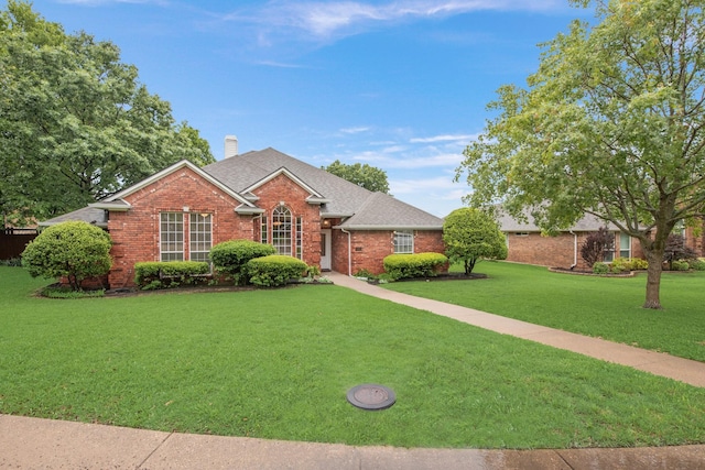 907 Sunpoint Cir, Rockwall, TX 75087 - view of front facade featuring a chimney, brick siding, a front yard, and a shingled roof
