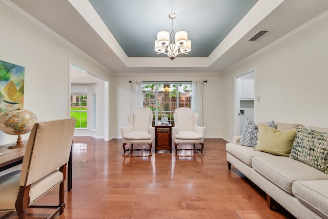 907 Sunpoint Cir, Rockwall, TX 75087 - living area with a chandelier, a tray ceiling, crown molding, wood finished floors, and baseboards