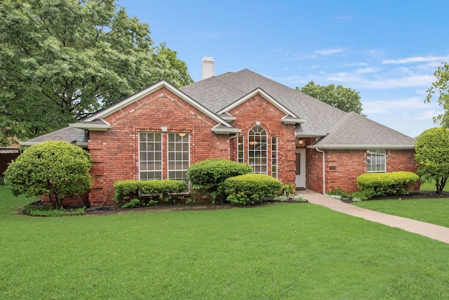 907 Sunpoint Cir, Rockwall, TX 75087 - view of front of home featuring brick siding, a front yard, a chimney, and roof with shingles
