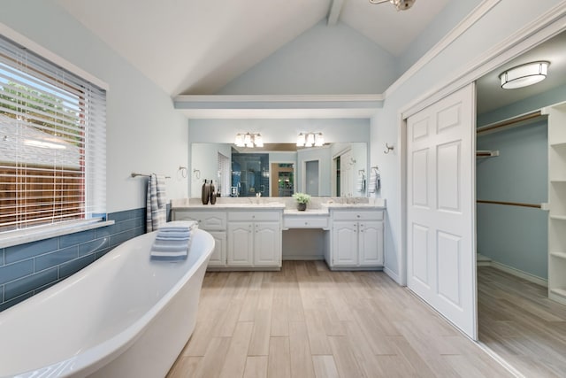 907 Sunpoint Cir, Rockwall, TX 75087 - bathroom with double vanity, a freestanding bath, wood finished floors, and a spacious closet