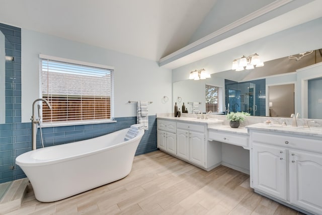 907 Sunpoint Cir, Rockwall, TX 75087 - bathroom with tile walls, double vanity, a freestanding tub, a shower stall, and vaulted ceiling