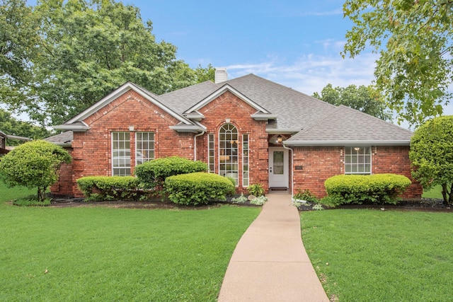 907 Sunpoint Cir, Rockwall, TX 75087 - view of front facade with brick siding, a front yard, and roof with shingles