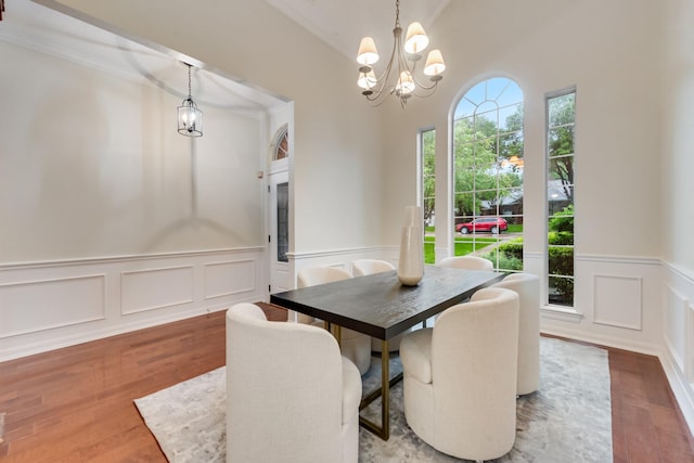 907 Sunpoint Cir, Rockwall, TX 75087 - dining area with a decorative wall, a chandelier, wood finished floors, and a wainscoted wall