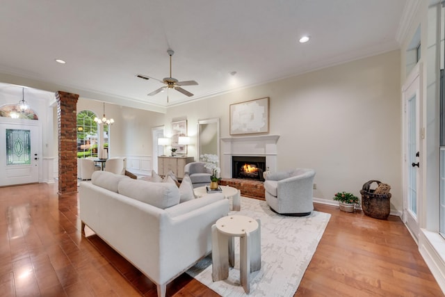 907 Sunpoint Cir, Rockwall, TX 75087 - living area featuring ornamental molding, decorative columns, wood finished floors, a brick fireplace, and a ceiling fan