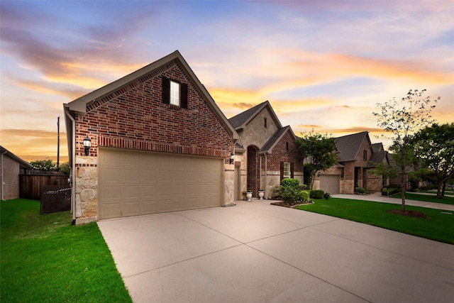 view of front of house featuring driveway, brick siding, stone siding, and a garage