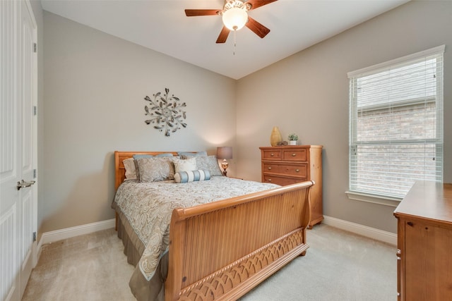 bedroom with light colored carpet, baseboards, and a ceiling fan