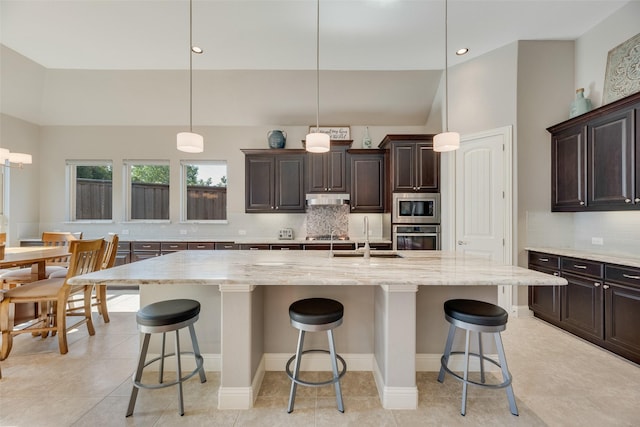 106 Magnolia Ln, Hickory Creek, TX 75065 - kitchen featuring appliances with stainless steel finishes, a sink, decorative backsplash, a kitchen breakfast bar, and under cabinet range hood