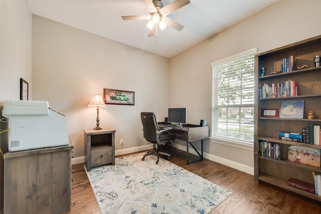 office space featuring a ceiling fan, healthy amount of natural light, baseboards, and wood finished floors