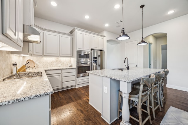 5400 Fringetree Dr, Mckinney, TX 75071 - kitchen with stainless steel appliances, arched walkways, a sink, tasteful backsplash, and dark wood-type flooring