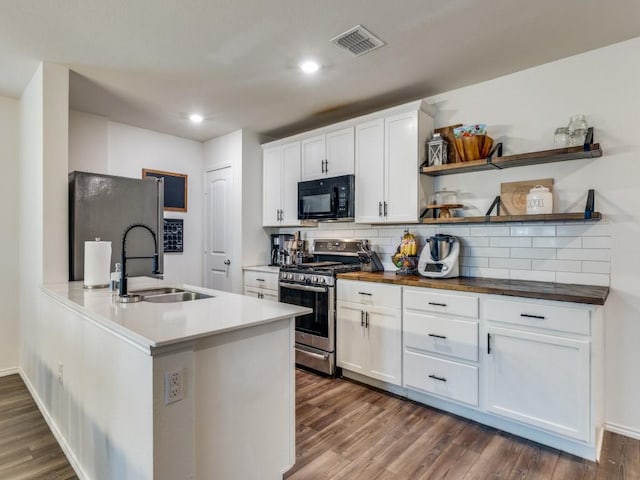 14340 Cloudview Way, Fort Worth, TX 76052 - kitchen featuring black microwave, stainless steel range with gas stovetop, a sink, tasteful backsplash, and dark wood-style flooring