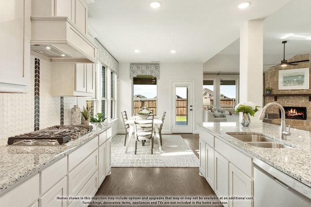 kitchen featuring dishwasher, a sink, dark wood-style floors, stainless steel gas stovetop, and open floor plan