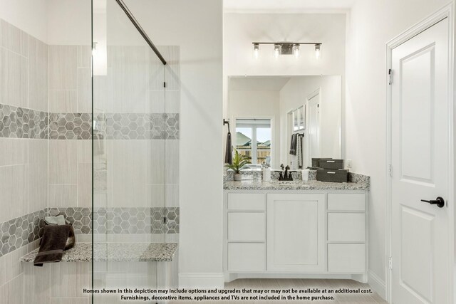 bathroom featuring walk in shower and vanity