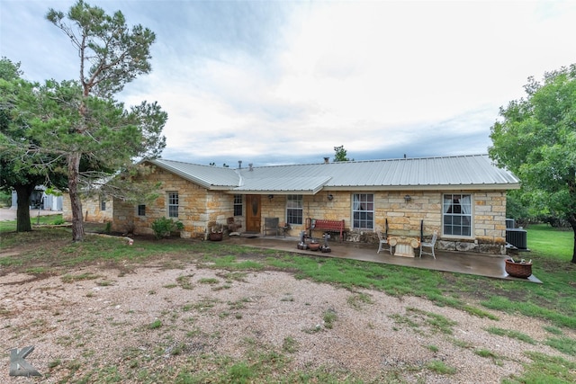 350 County Road 606 Unit B, Tuscola, TX 79562 - back of property with stone siding, a patio, metal roof, and central AC unit