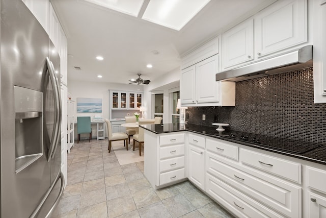 kitchen featuring stainless steel fridge, under cabinet range hood, a peninsula, backsplash, and white cabinets