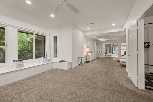 hallway featuring recessed lighting, carpet flooring, a tray ceiling, and baseboards