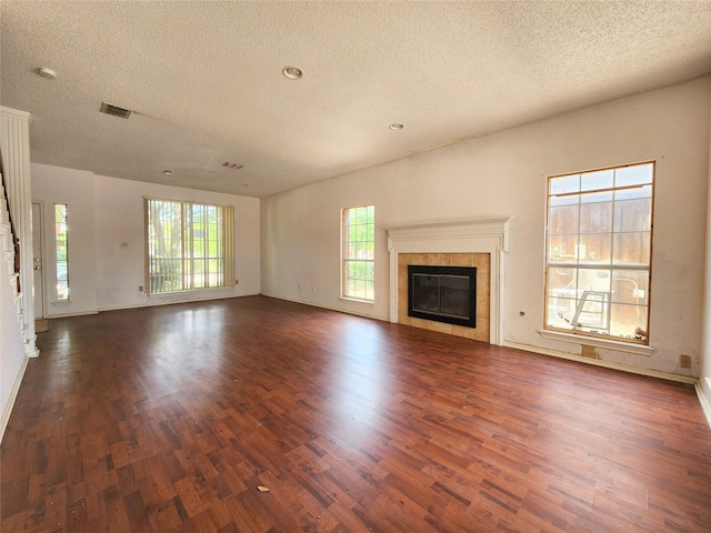 unfurnished living room with wood finished floors, stairs, a textured ceiling, recessed lighting, and baseboards