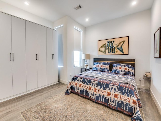 bedroom with wood finished floors, baseboards, and recessed lighting