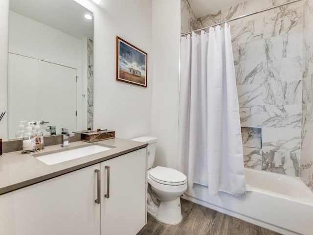 bathroom featuring toilet, wood finished floors, shower / tub combo with curtain, and vanity