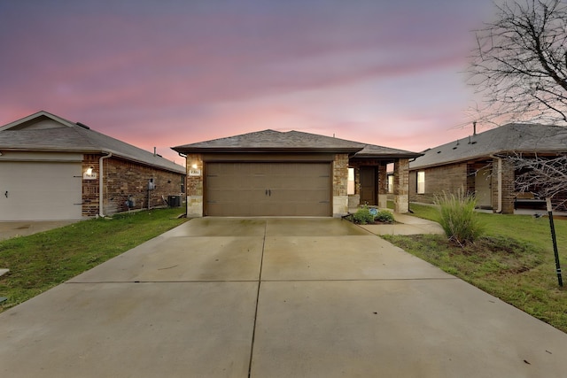 ranch-style home with concrete driveway, cooling unit, a garage, and a yard