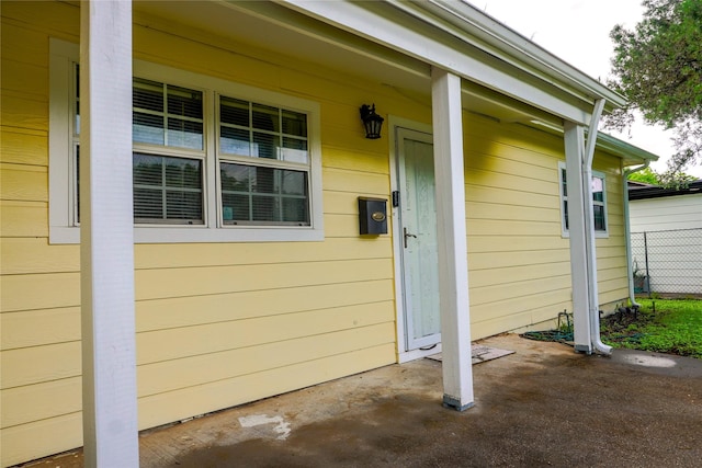 view of exterior entry featuring covered porch
