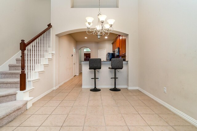 3644 Vienna St, Irving, TX 75038 - foyer featuring arched walkways, a towering ceiling, a chandelier, stairway, and light tile patterned floors