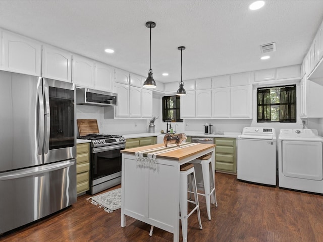 138 Selma Rd, Bowie, TX 76230 - kitchen featuring stainless steel appliances, washing machine and clothes dryer, dark wood-style floors, white cabinets, and recessed lighting