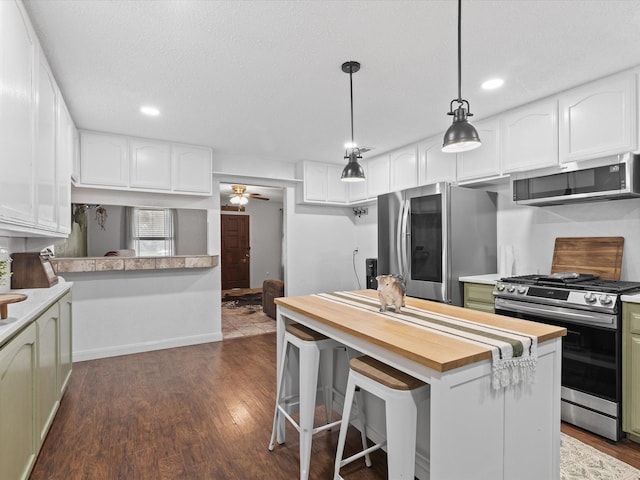 138 Selma Rd, Bowie, TX 76230 - kitchen featuring stainless steel appliances, white cabinets, wood counters, and recessed lighting