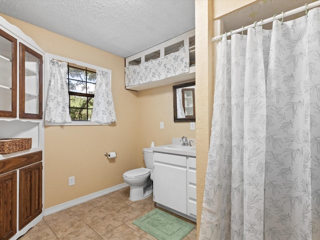138 Selma Rd, Bowie, TX 76230 - bathroom with vanity, toilet, a textured ceiling, baseboards, and tile patterned flooring