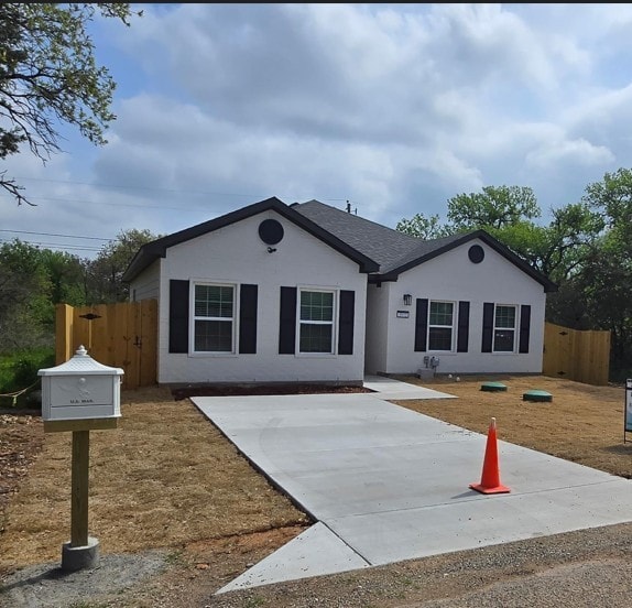 ranch-style home featuring fence and stucco siding
