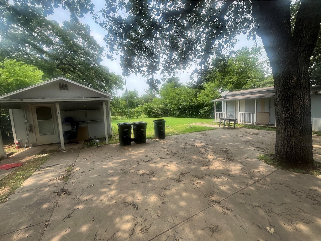 view of patio featuring concrete driveway and a carport