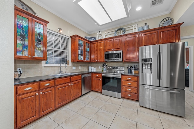 10612 Calaveras Dr, Waco, TX 76708 - kitchen featuring appliances with stainless steel finishes, a sink, dark countertops, decorative backsplash, and ornamental molding