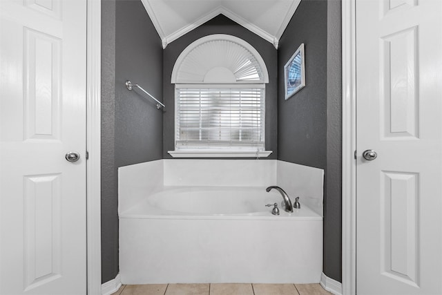 10612 Calaveras Dr, Waco, TX 76708 - full bath featuring a textured wall, crown molding, a bath, vaulted ceiling, and tile patterned floors