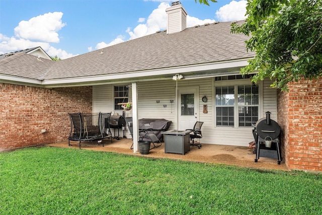 10612 Calaveras Dr, Waco, TX 76708 - back of house with a shingled roof, a patio, a lawn, brick siding, and a chimney