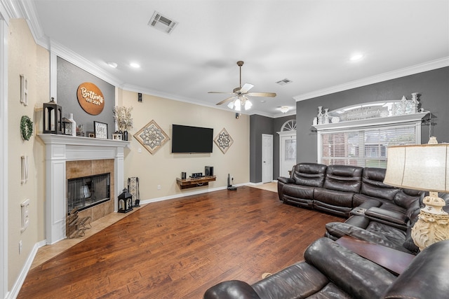 10612 Calaveras Dr, Waco, TX 76708 - living area with ceiling fan, wood finished floors, a tiled fireplace, recessed lighting, and crown molding
