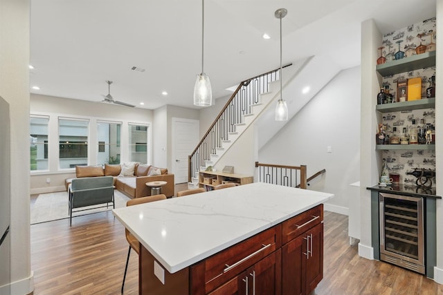 461 Rayner Ave, Fort Worth, TX 76111 - kitchen featuring wine cooler, wood finished floors, recessed lighting, hanging light fixtures, and a kitchen breakfast bar