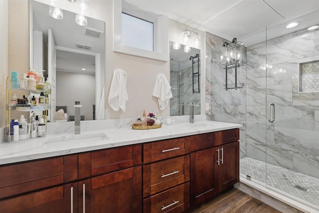 461 Rayner Ave, Fort Worth, TX 76111 - bathroom with a marble finish shower, double vanity, wood finished floors, and recessed lighting