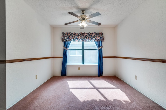 carpeted empty room with a textured ceiling, ceiling fan, and a textured wall