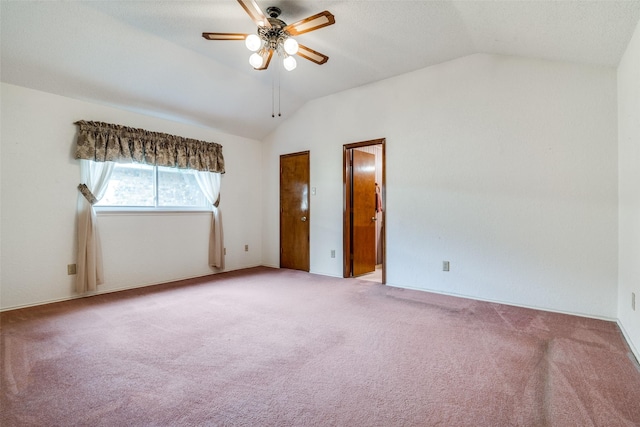 empty room featuring lofted ceiling, a ceiling fan, and carpet floors